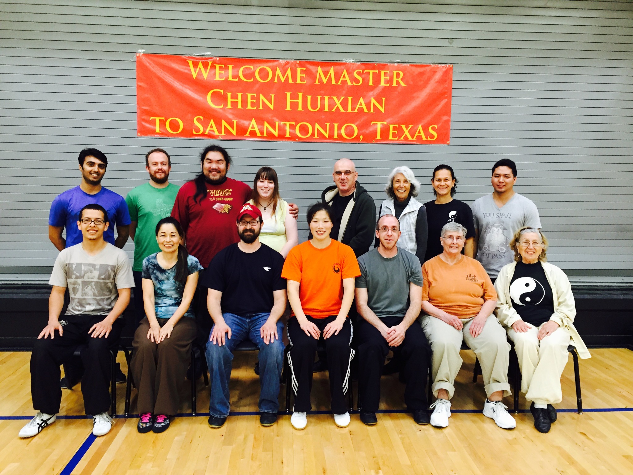 Master Chen Huixian with San Antonio workshop participants beneath a welcome banner